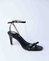Black sandal with a clear plastic cover on a white background