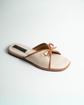 Beige slipper with brown bow on a light gray background