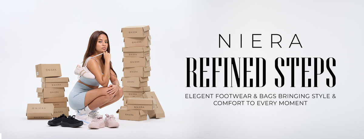 A promotional banner for Niera Refined Steps featuring a woman crouching among tall stacks of branded cardboard shoe boxes on a white studio background, with large black text reading 'NIERA REFINED STEPS' and smaller tagline text.