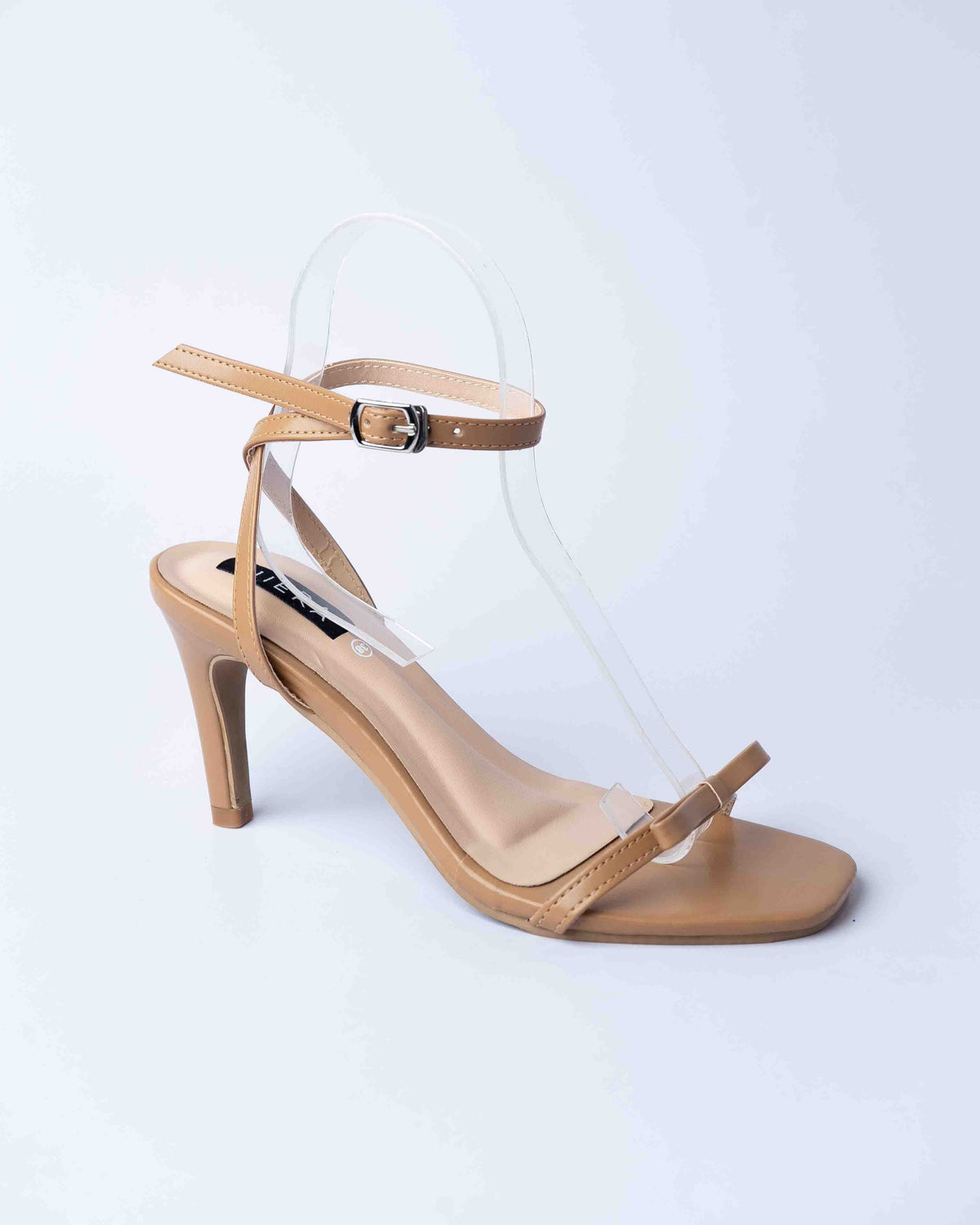 Beige high-heeled sandal with thin straps on a light gray background