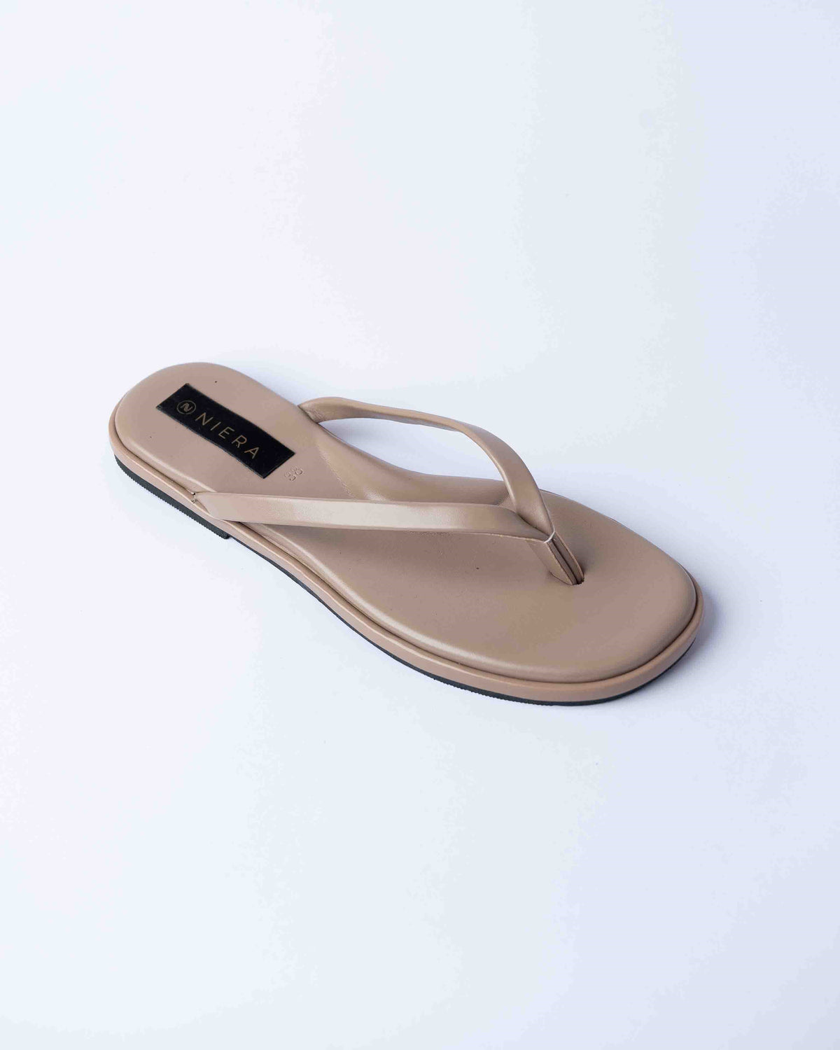 Beige sandal with a brand label on a light gray background