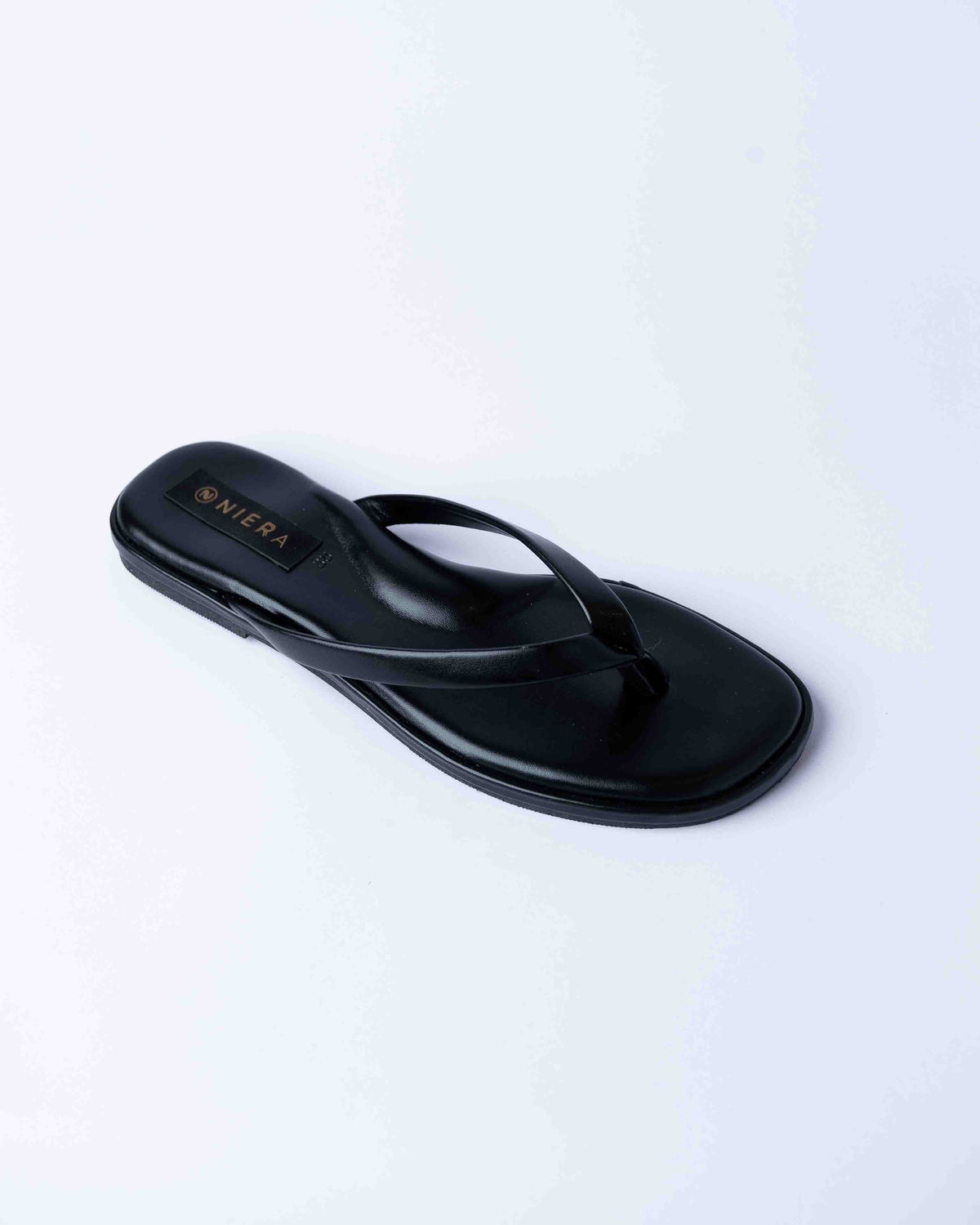 Black sandal with a brand logo on a light gray background
